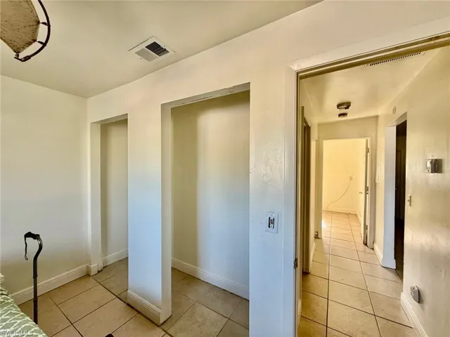 Interior space featuring light-toned walls, tile flooring, and built-in wall recesses