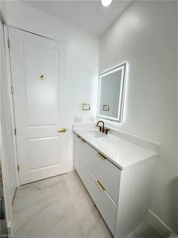 Bathroom featuring light marble finish flooring and vanity