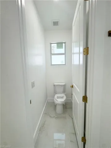 Bathroom featuring baseboards and light marble finish floors