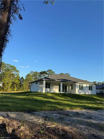 View of front of home with a front lawn and stucco siding