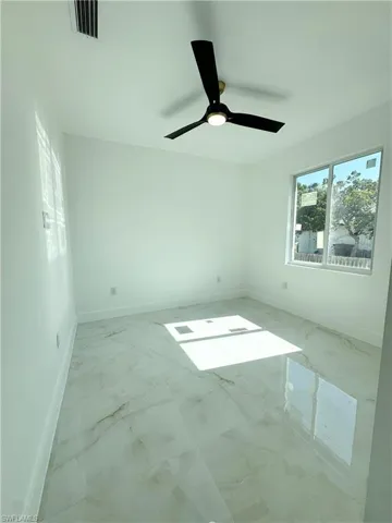 Unfurnished room with baseboards and a ceiling fan