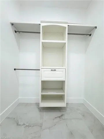 Spacious closet with light marble finish flooring