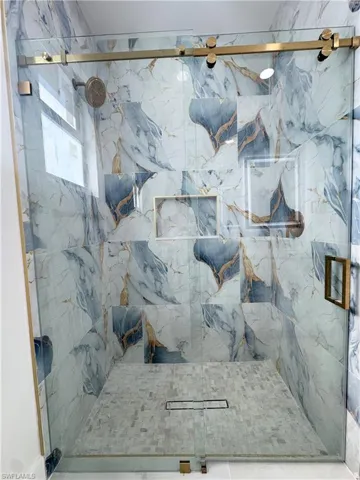 Bathroom featuring a marble finish shower