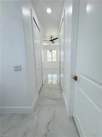 Corridor featuring light marble finish flooring and recessed lighting