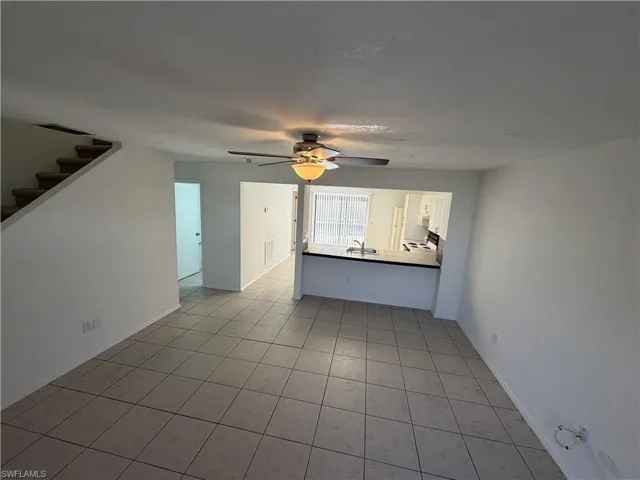Unfurnished living room with light tile patterned floors and a ceiling fan