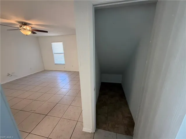 Stairway with a ceiling fan and tile patterned floors