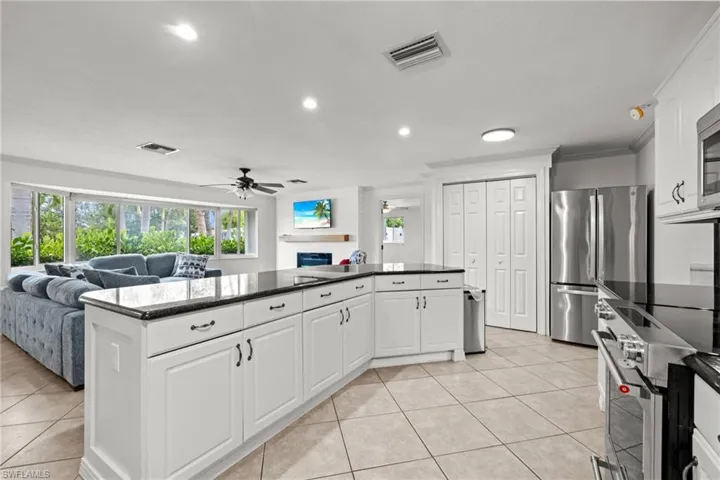 Kitchen featuring stainless steel appliances, open floor plan, a ceiling fan, light tile patterned floors, and recessed lighting
