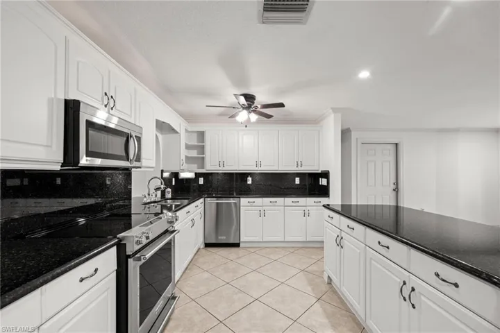 Kitchen with stainless steel appliances, open shelves, a sink, white cabinetry, and recessed lighting