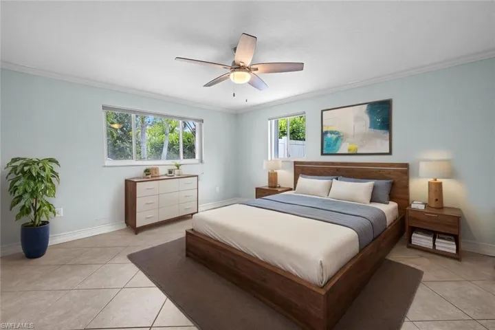 Spare room featuring ceiling fan, light tile patterned flooring, crown molding, baseboards, and a smoke detector