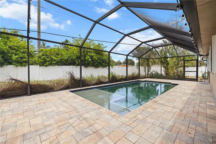 View of swimming pool featuring a patio area, a fenced backyard, and a lanai