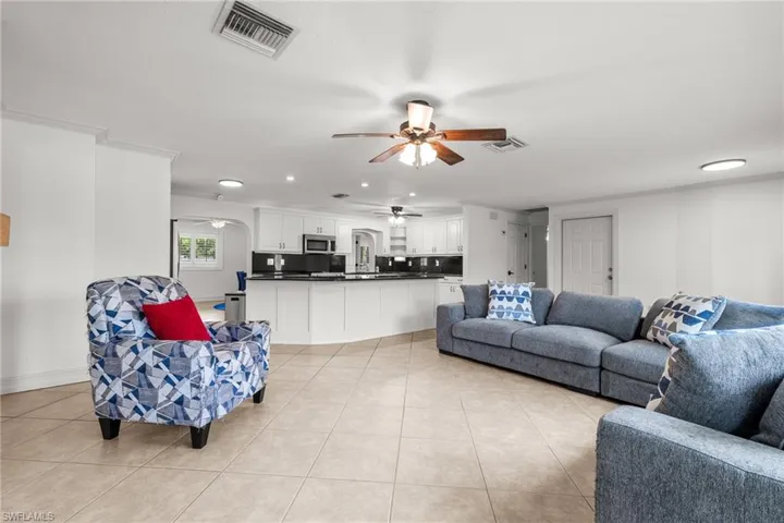 Living room featuring ceiling fan, light tile patterned floors, and recessed lighting