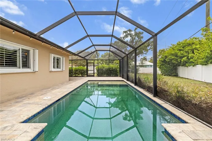 Outdoor pool featuring a fenced backyard and a patio area