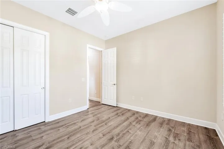 Unfurnished bedroom with a closet, wood-type flooring, and ceiling fan