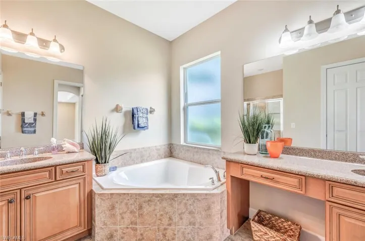 Bathroom with vanity and tiled bath