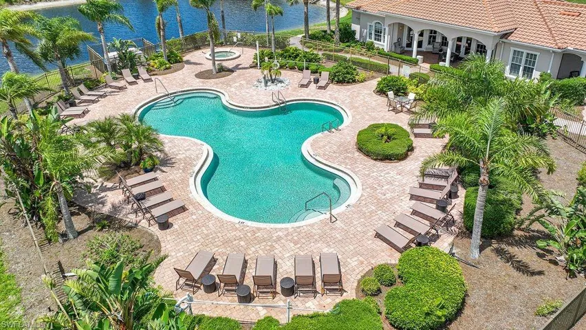 Community pool with a patio area, a water view, and a hot tub