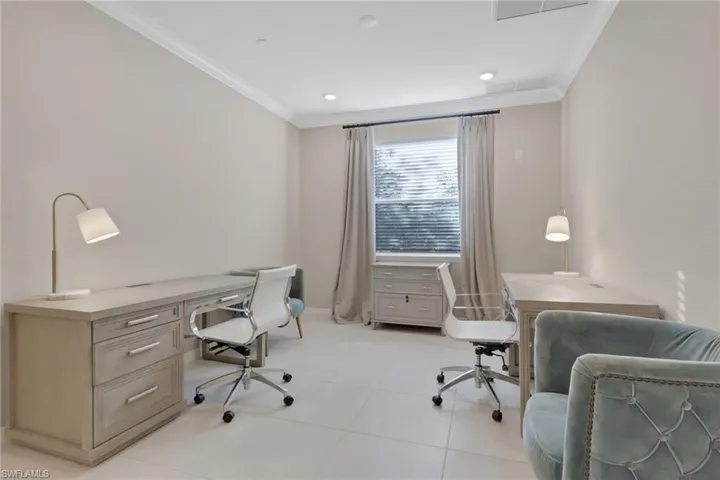 Office space with crown molding and light tile patterned flooring