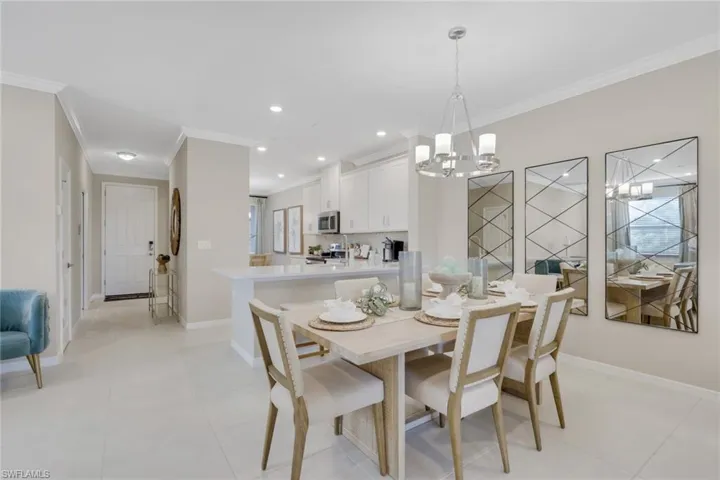 Dining area with ornamental molding, light tile patterned floors, recessed lighting, and a chandelier