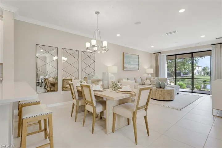 Dining area with ornamental molding, recessed lighting, a chandelier, and light tile patterned floors