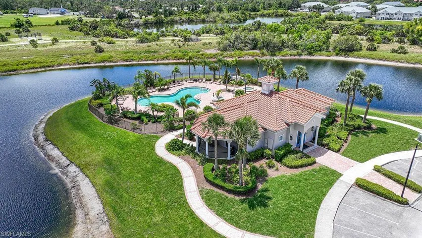 Drone / aerial view of Community Clubhouse large body of water and a pool