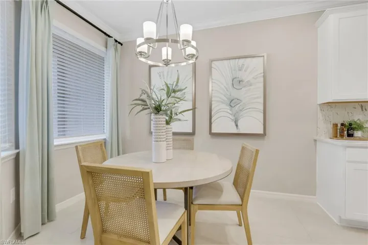 Dining room featuring a chandelier, ornamental molding, and light tile patterned flooring