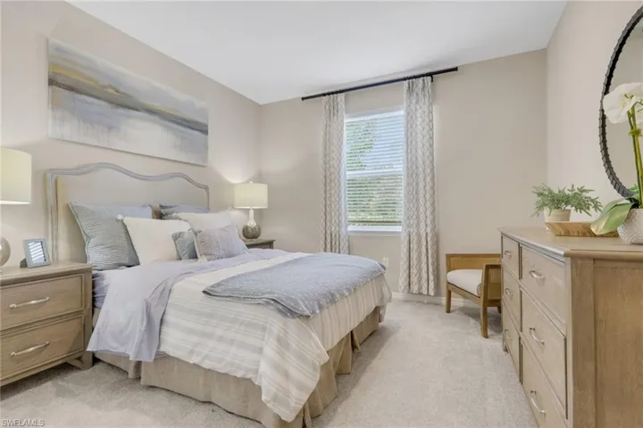 Bedroom with light colored carpet and baseboards