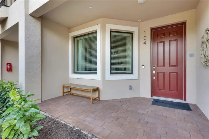 View of exterior entry with stucco siding and a porch