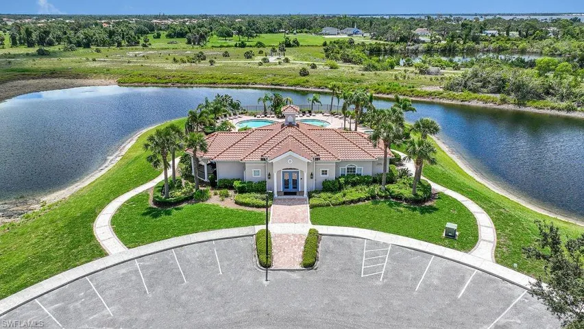 Aerial view of Community Clubhouse and surrounding area with a large body of water and a tree filled landscape