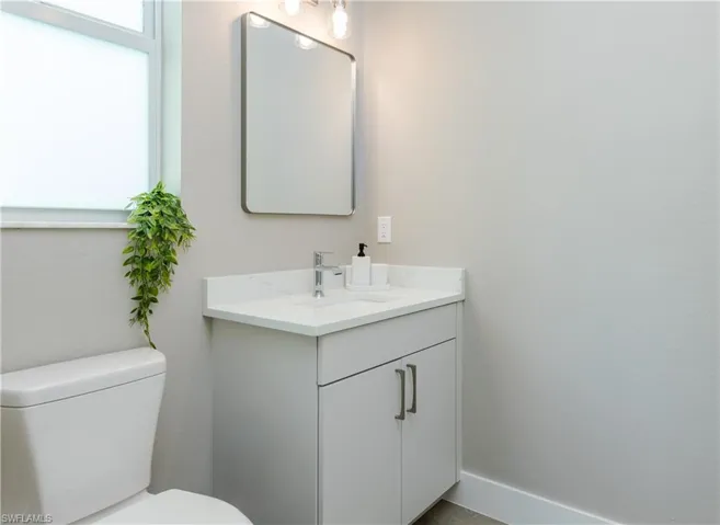 3-Level Bathroom with white countertop, chrome faucet, and cabinet storage