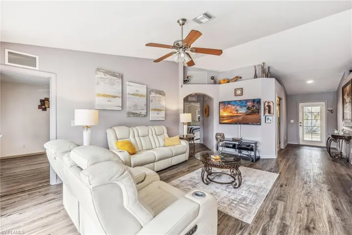 Den with french doors, carpet, ceiling fan.