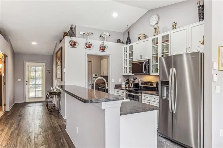 Great room featuring vaulted ceiling, ceiling fan, arched doorways, and LVF floors.
