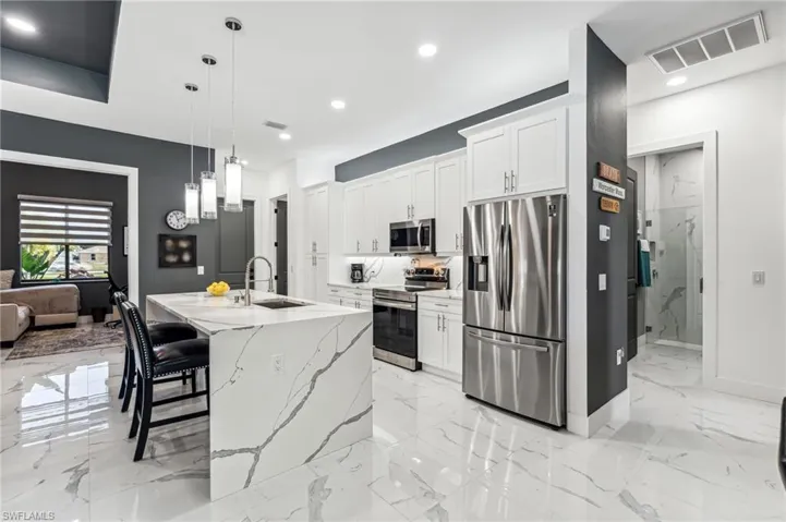 Kitchen featuring visible vents, a sink, stainless steel appliances, and marble finish floor