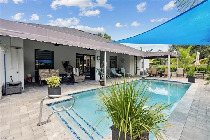 Outdoor pool with an outdoor living space and a patio