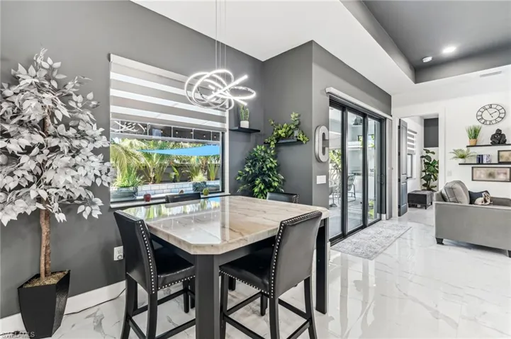 Dining area with marble finish floor, a healthy amount of sunlight, visible vents, and a chandelier