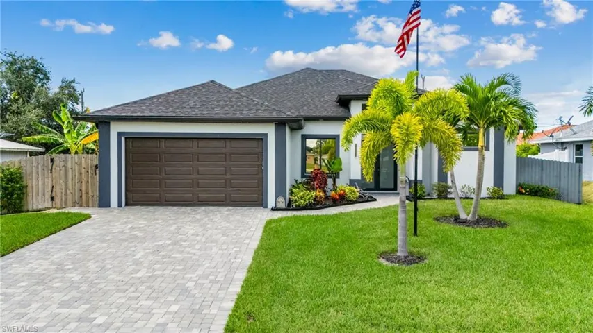 View of front of house featuring a front yard, stucco siding, fence, and a shingled roof