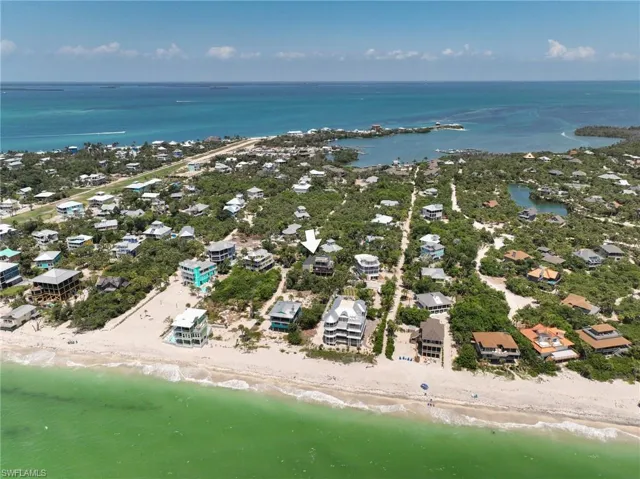 Birds eye view of property featuring a view of the beach and a water view