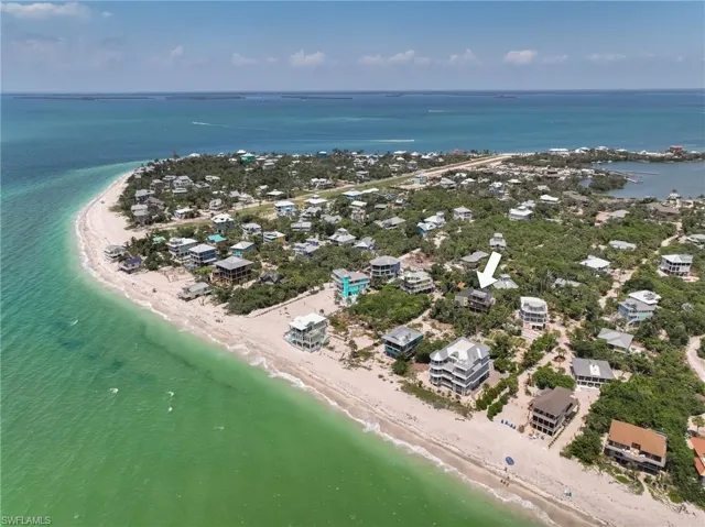 Birds eye view of property featuring a beach view and a water view