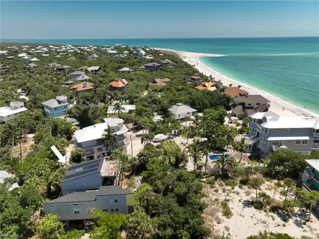 Birds eye view of property featuring a view of the beach and a water view