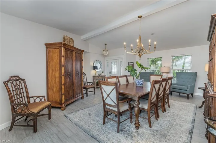 Dining space featuring a chandelier, plank style flooring, and lofted ceiling