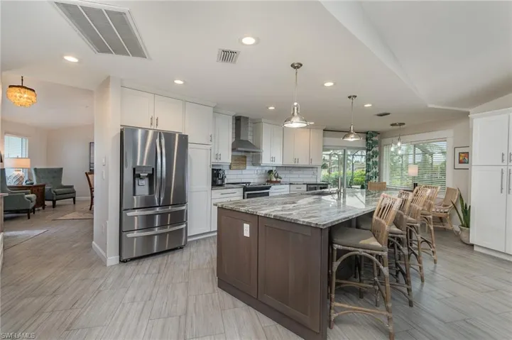 Kitchen featuring a spacious island, vented exhaust hood appliances, stainless steel appliances