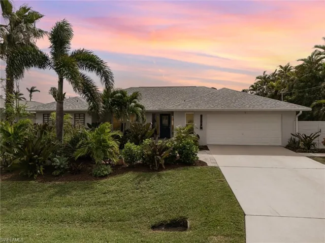 View of front of house with a front lawn, driveway, an attached garage, roof with shingles, and stucco siding