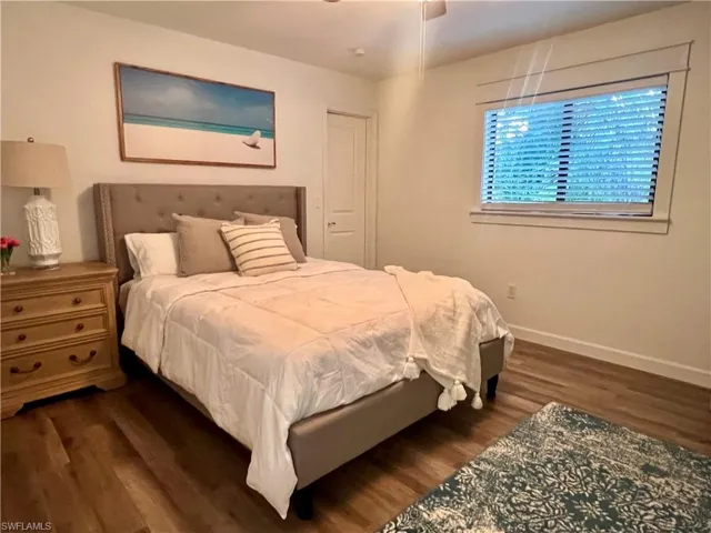 Bedroom featuring dark wood-type flooring and baseboards