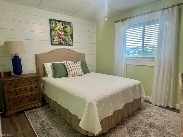Bedroom with wood walls and wood finished floors