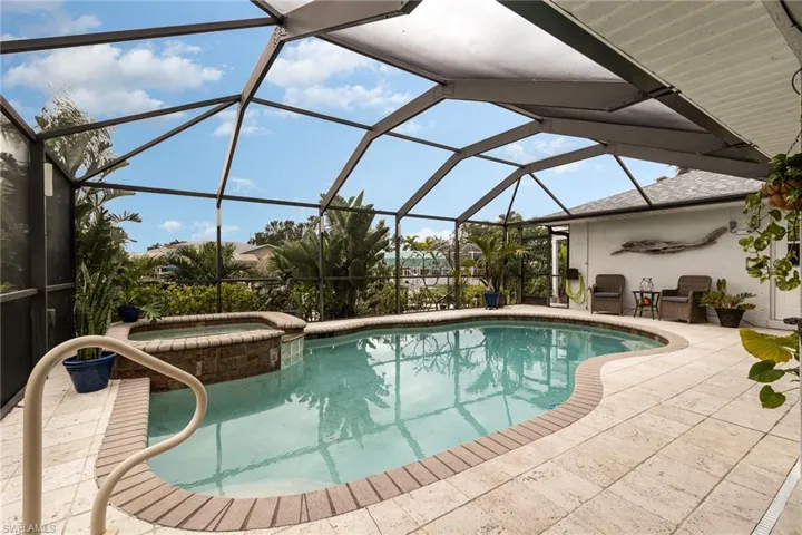 View of pool with an in ground spa a patio area, and a lanai