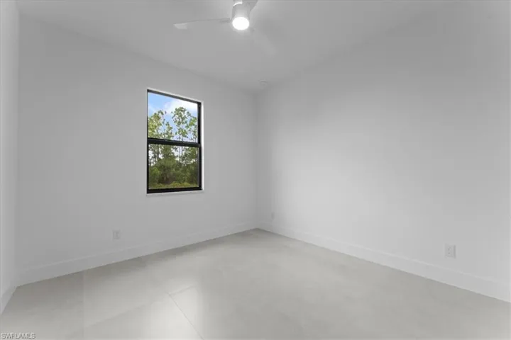 Empty room with baseboards and a ceiling fan