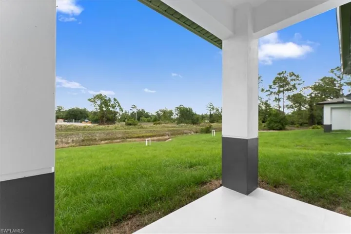 View of green lawn featuring a patio