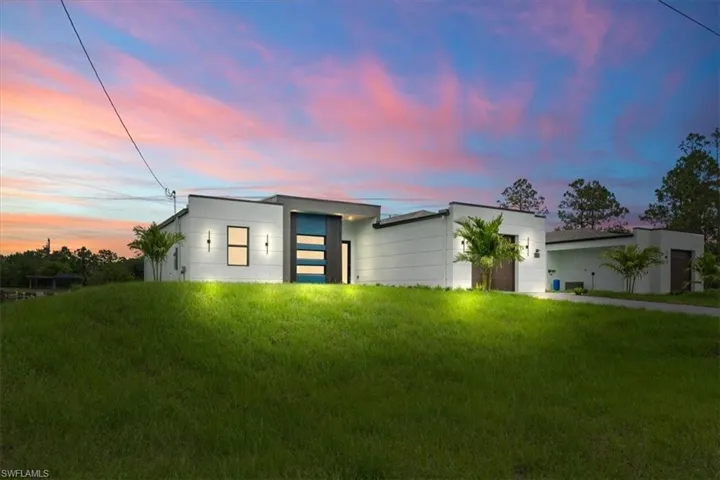 Contemporary house featuring a garage and a front lawn