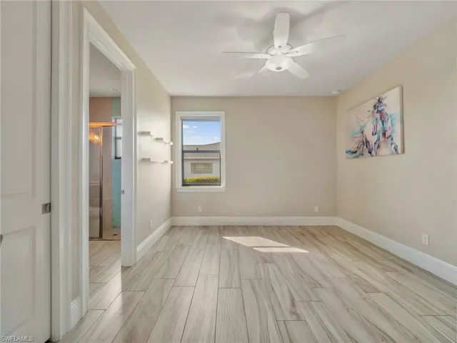 Spare room featuring light wood-style floors, ceiling fan, and baseboards