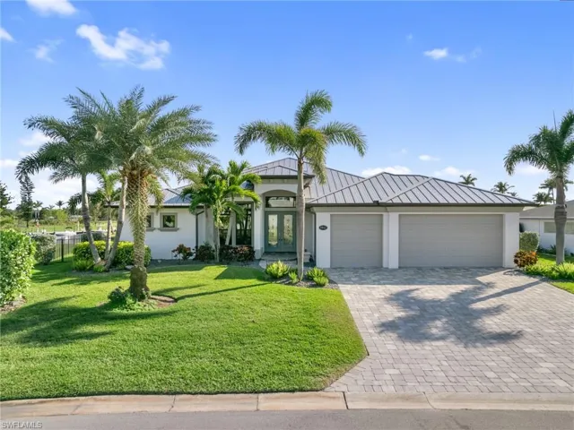 Mediterranean / spanish house with stucco siding, metal roof, a standing seam roof, french doors, and a front yard