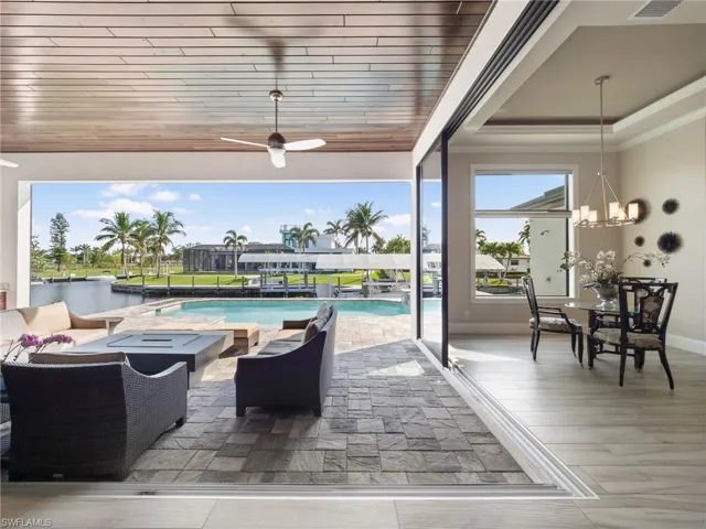 View of patio / terrace featuring visible vents, an outdoor pool, ceiling fan, a water view, and an outdoor living space