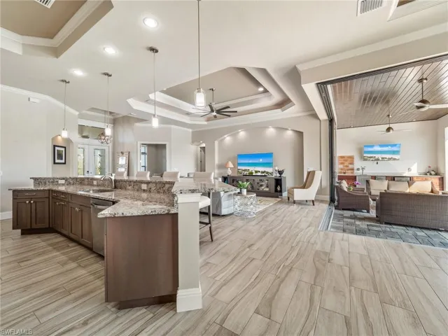 Kitchen with open floor plan, hanging light fixtures, a tray ceiling, and dishwasher